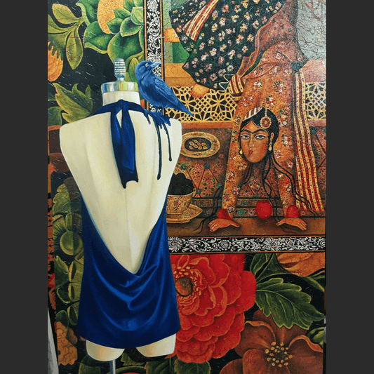 Colorful artwork showing a mannequin draped in a deep blue halter-back dress with a perched blue bird, set against a vibrant background of traditional Persian-style patterns, flowers, and an ornate female figure